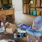 Kurni dan Novi sedang membuat pita dari kertas bekas di Rumah Hijau Denassa (RHD)