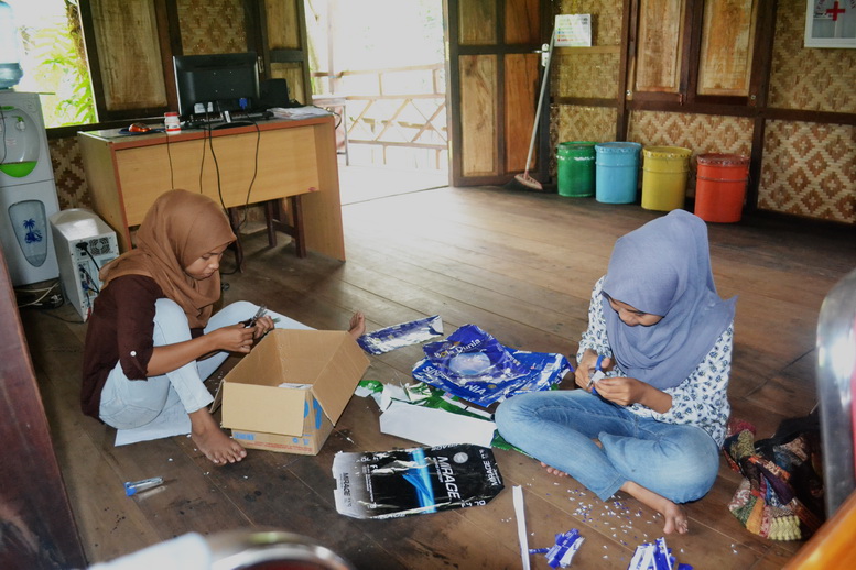 Kurni dan Novi sedang membuat pita dari kertas bekas di Rumah Hijau Denassa (RHD)